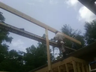 Carpenter setting a ridge beam over a new addition frame — Ice Dam Removal by Roofing Brothers in Brownsboro