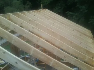 New roof rafters set over an addition before sheathing in Brownsboro