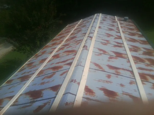 Rusted metal roof panels with new wood purlins before replacement — Storm Damage Roof Repair in Brownsboro by Roofing Brothers