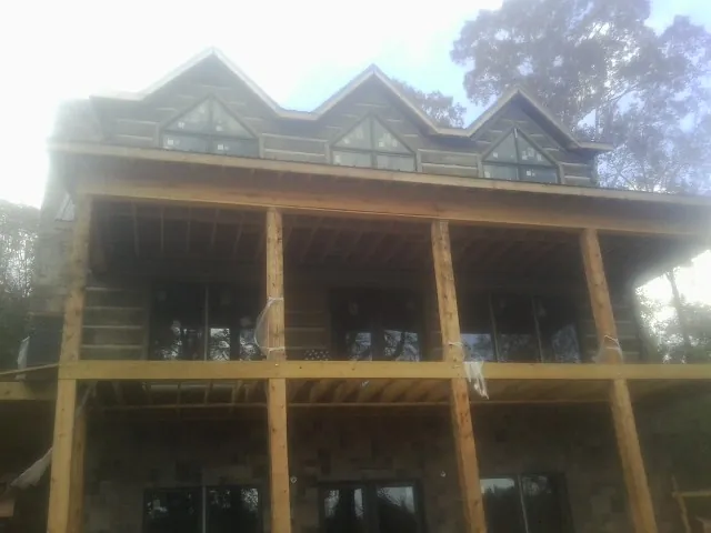 Dormers and porch framing on a large log home under construction — Roof Coating work by our crew in Brownsboro